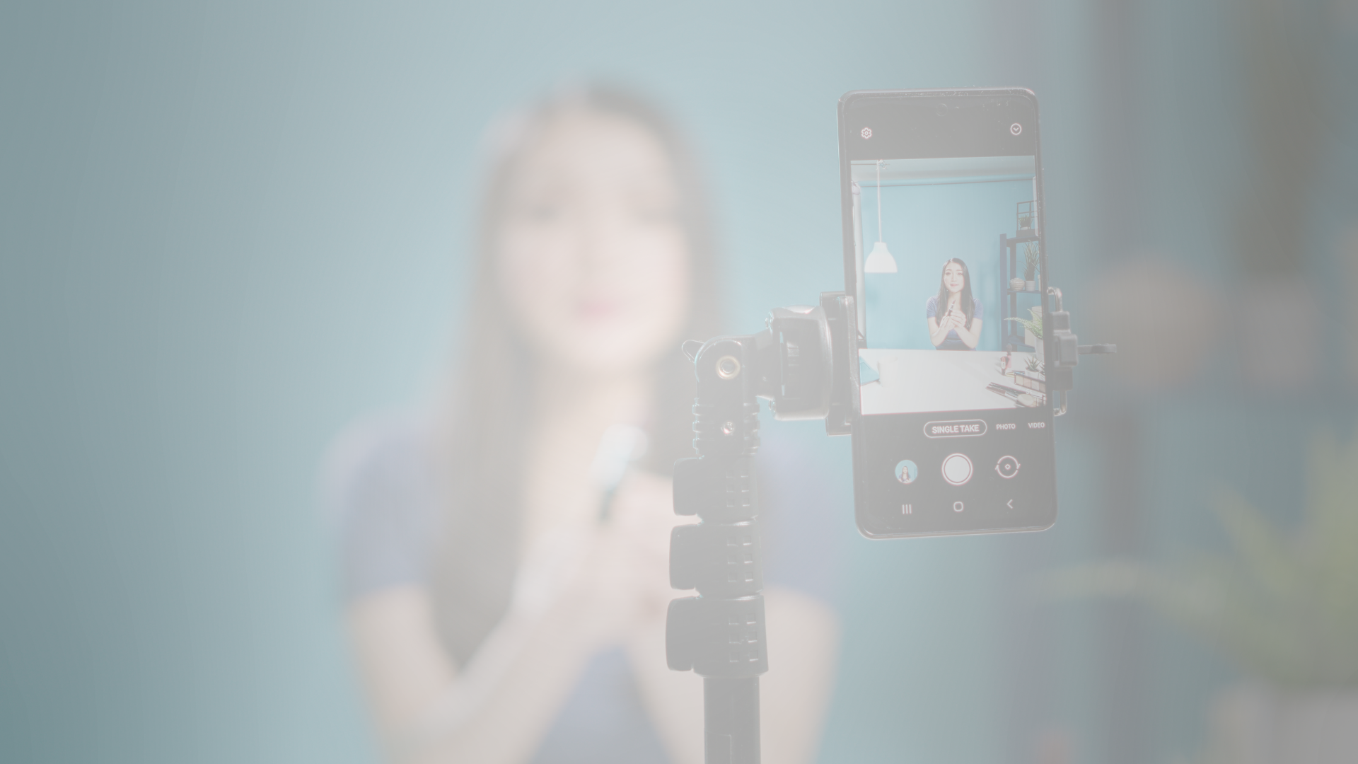 woman recoding a video using her cell phone in a stand